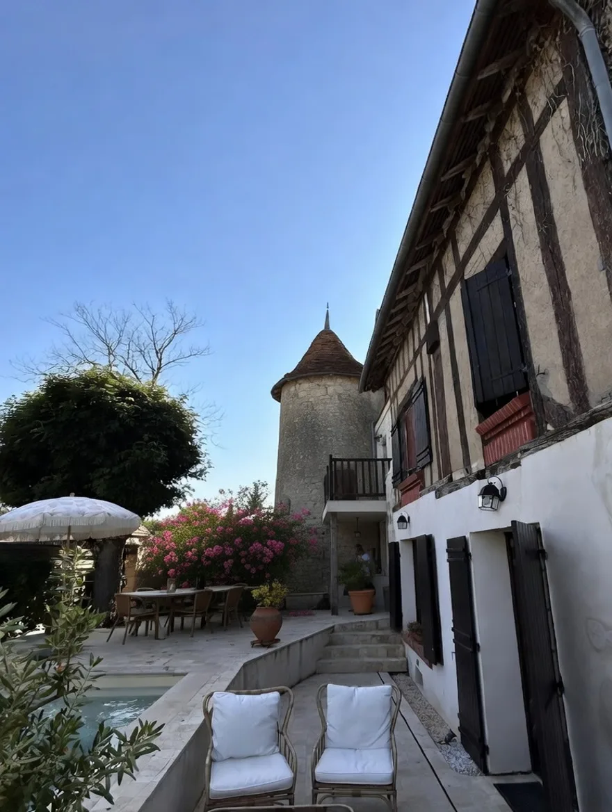 La Tour du XIIᵉ siècle vue depuis la terrasse et la piscine